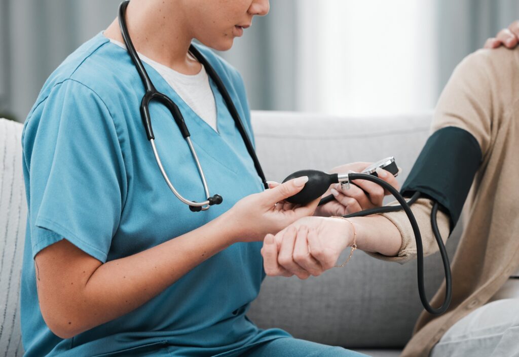 Blood pressure, caregiver nurse and woman patient on a nursing home for health and wellness check.