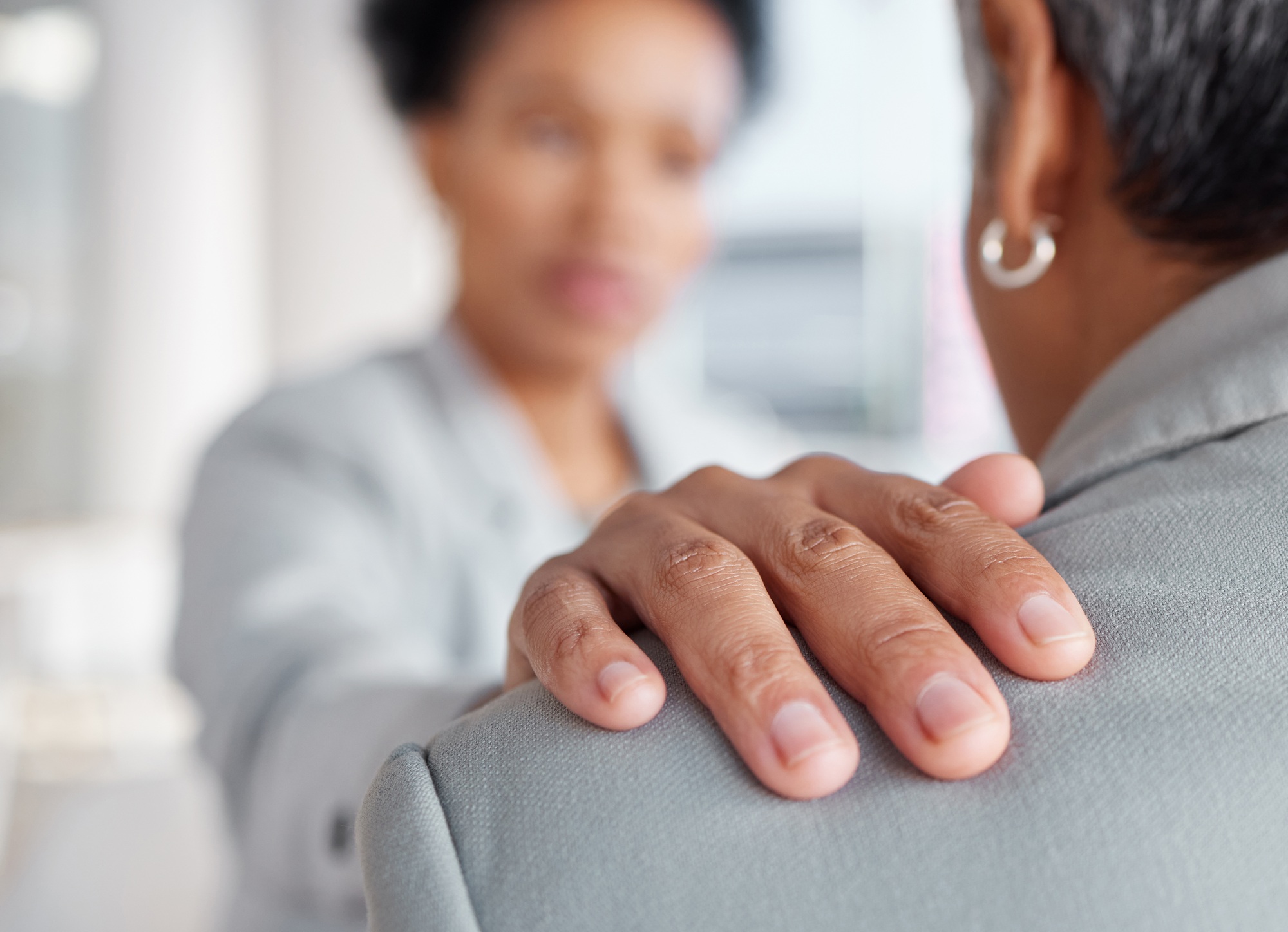 Hand on shoulder, support and women in counselling at work, stress and mental health, closeup with
